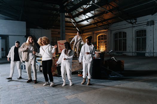 A group of diverse individuals performing a modern dance in an urban industrial setting.